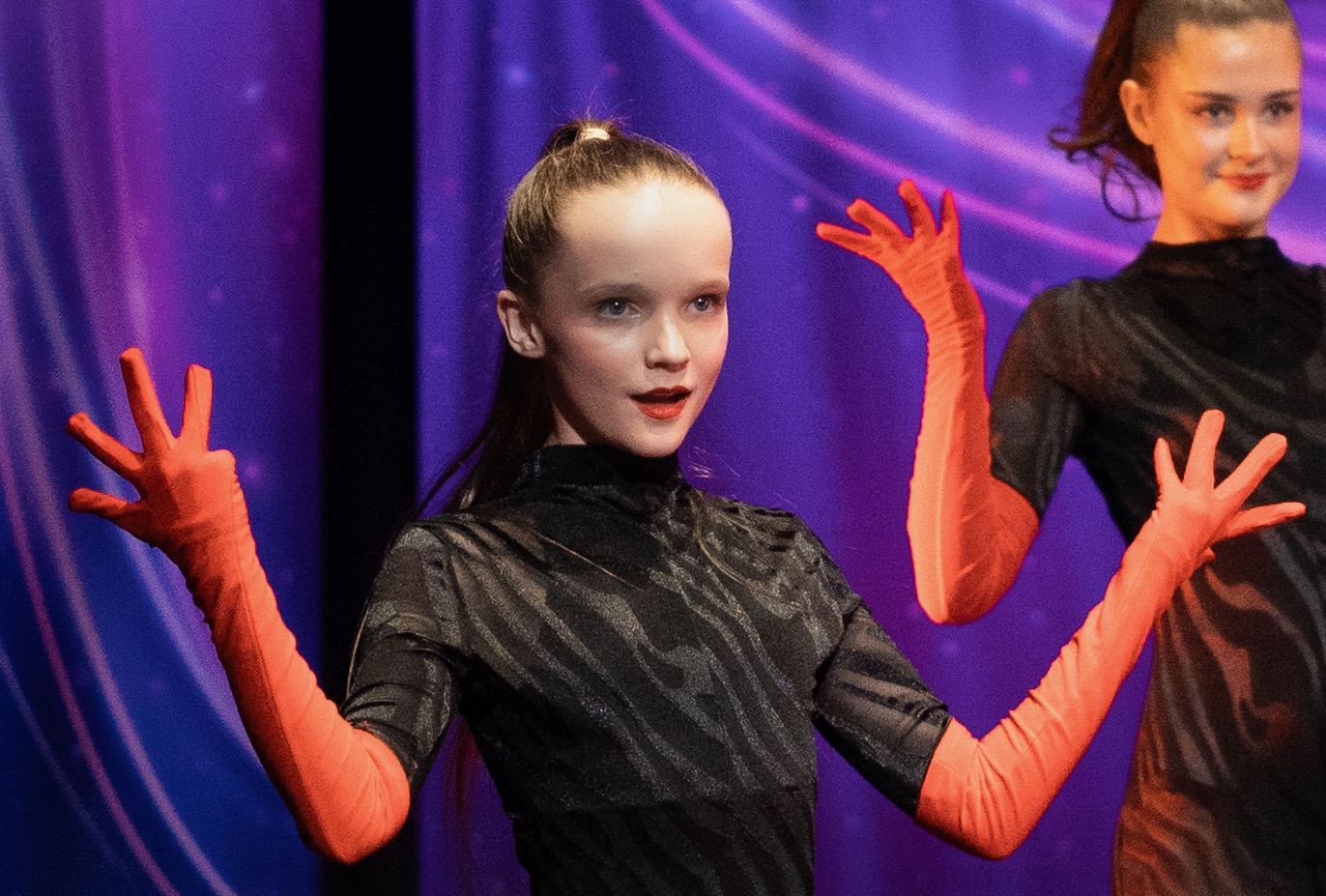 Dancer performing on stage with red gloves