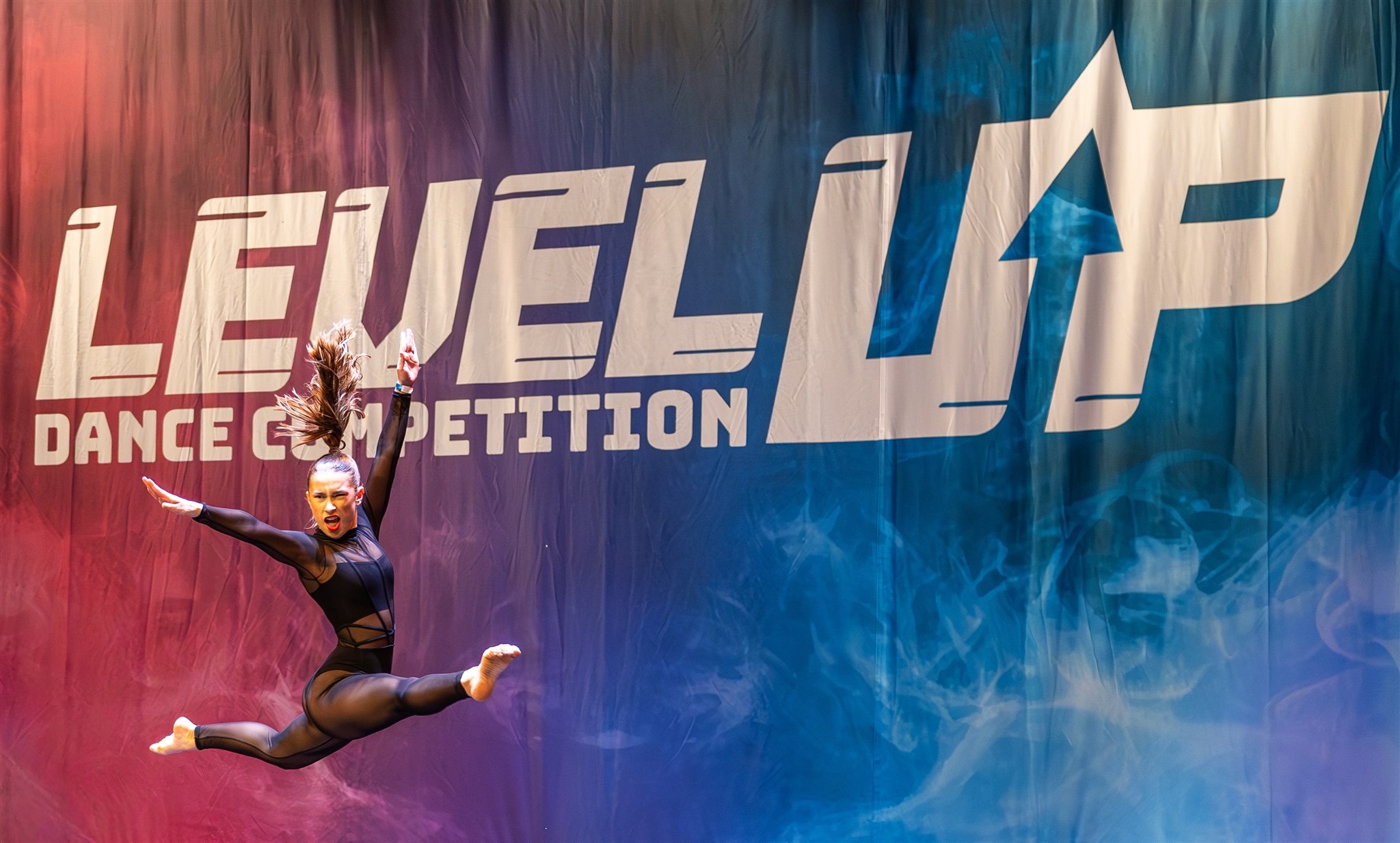 Dancer mid-leap at Level Up dance competition