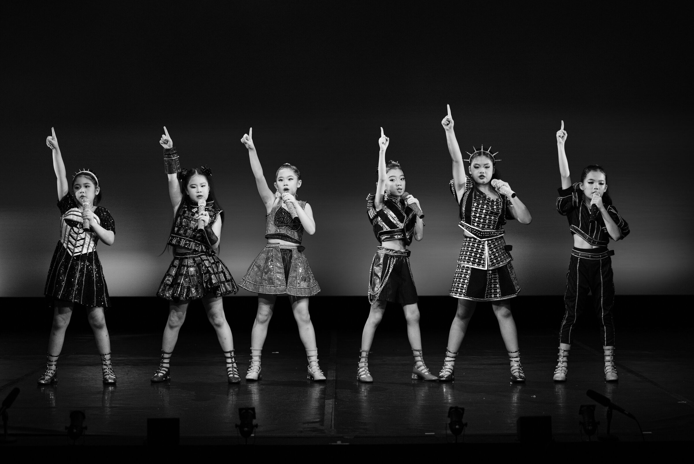 Six young performers in matching sequinned costumes posed together on stage, Six: Teen Edition